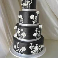 Black And White Wedding Cake Black fondant with royal icing piping and gumpaste flowers.