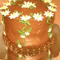 Daisy Cake chocolate cake filled with white chocolate ganache, covered in chocolate buttercream and decorated with gumpaste daisies