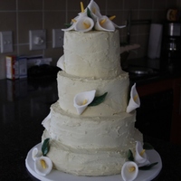 White Ganache 4 Tier Lily Cake THIS IS MY 1ST WEDDING CAKE AND MY 1ST ATTEMPT AT DOING FLOWERS. THE CLIENT REQUESTED A "ROUGH" LOOKING ICING BUT I STRUGGLED...