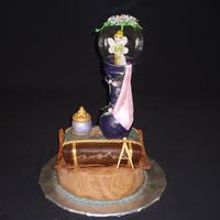 Tinkerbell Snowglobe Statue This is a 10" round marbled vanilla and chocolate cake with a fondant scroll then a vanilla book on top. The vase and small jar are...