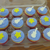Hannah Montana Theme Vanilla Cupcakes with cream cheese frosting. Toppers are fondant stars and white chocolate guitars. TFL