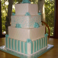 Blue And White Wedding Cake Buttercream frosted with gumpaste roses and fondant stripes on the bottom tier.