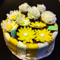 Flower Pot Moist Yellow cake with chocolate frosting . All the flowers are made from marshmellow fondant.
