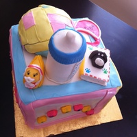 Baby Block The design of the cake was a baby block with a small patch ball on the top. Also , on top are some of her favorite things : her dr. brown...