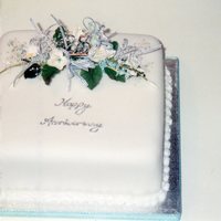 Silver Wedding Cake Fruit cake base covered with marzipan and sugarpaste. Plain looking but for the handmade flower spray on the top made with flowerpaste.