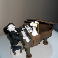 Piano Man This is a little man and piano made entirely from icing. It sits on a 6" iced plaque board. I made it for a mans birthday cake.
