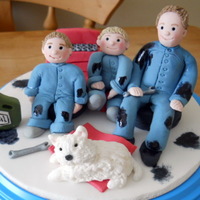 Mechanics This topper is on a 6" iced board with hand made figures of the Daddy and his two boys and their dog. They are all made from icing.