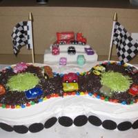 Lightning Mcqueen Racetrack two 10 inch round cakes iced with buttercream. Crushed oreos for the road and oreos around the bottom. The grandstand is made out of rice...