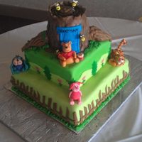 Winnie The Pooh Cake This a a winnie the pooh cake. The tree is RCT covered in fondant. The remainder is cake covered in butter creams and fondant detail. The...