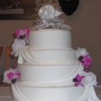 Traditional Wedding Cake 4 Tier Traditional Wedding cake with Marsh-mello fondant drapes and Lavender orchids.