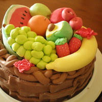 A Basket Of Fruits A white cake filled with mango filling. Cake is covered in fondant and fruits are made out of gumpaste.