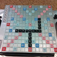 Scrabble Cake Life sized scrabble board atop a yellow cake covered in Satin Ice Black Fondant. This cake was modeled after the Onyx version of Scrabble...