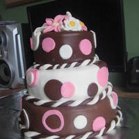 Pink/brown Tier Cake Three tier cake, Two chocolate cakes with filling and one vanilla cake with filling. Fondant covering.