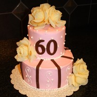 Pink And Pearls Buttercream Cake Pink Buttercream with sugar pearls and chocolate fondant accents. The flowers are fake. Inside is mango icing with mango puree yellow cake...