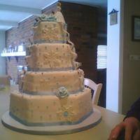 Hexagon With Snowflakes, Dots, Ribbons And Bows This was is a Hexagon wedding cake. embellished with snowflakes, ribbons, bows, roses and dots. white with ice blue.