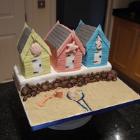Beach Huts the huts were all made from cake and the base. Rocks were made from sugarpaste, the moat was from piping gel swirled with colour and the...