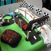 Race Car Cake This is a race car cake I made for my friend's son. He was turning 9 as you can tell from the race track. The cars are handmade by my...