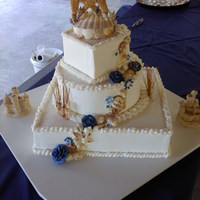 Beach Wedding All buttercream. Bottom tier vanilla w/ strawberry, middle choc/choc, top peanut butter cake w/ choc filling. Shells and fence are...