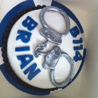 Handcuffs a police officer's birthday cake - old fashioned handcuffs (for his age!) and his badge details