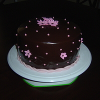 Chocolate Ganache Dobash cake with chocolate pudding filling covered in chocolate butter cream and topped of with a ganache and fondant flowers