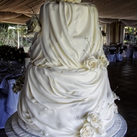 Drapes This was my first attempt with drapes. The cake consists of four tiers. The roses is icing and the diamante's is not edible.