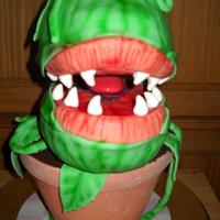 1302483639.jpg This is a 3-D cake representation of "Audrey II" from "Little Shop Of Horrors". It was made for the lead actor playing...