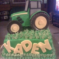 Tractor Cake A tractor cake for a little boy's 2nd birthday. The tractor is made of cake, covered in fondant. The grass is buttercream. The cake is...