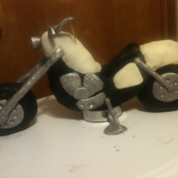 Motorcycle I made this out of rice crispys and covered in modeling chocolate. I then put it on a round cake covered in orange fondant but forgot to...