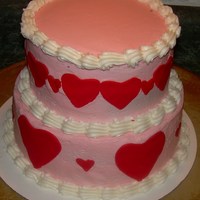 Valentine's Day Cake Top layer is red velvet, bottom layer is strawberry. Buttercream frosting with fondant hearts.