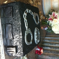 Officer Scott's Groom's Cake Red velvet cake and buttercream icing. Badge, handcuffs, and belt are chocolate fondant.