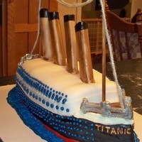 Titanic 1 half-sheet yellow cake and half of 1 half-sheet white stacked, dowled and carved. Then crumb coated and covered in fondant. the railing...