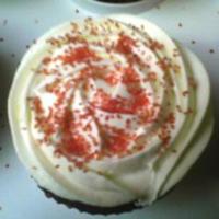 Red Velvet Cc W/ Wccc Frosting White Chocolate Cream Cheese Frosting Piped as a Rose garnished w/ Red Sugar on Red Velvet Cupcakes