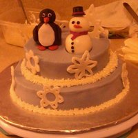My First Christmas Cake (And Second Cake Ever) Made for my boss and his wife. Triple chocolate cake, raspberry filling, BC icing. Snowman, penguin, and snowflakes are fondant.