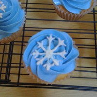 Winter Cupcakes :) Lemon cupcakes filled with raspberry jam. Topped with vanilla Swiss meringue butter cream. Snowflake was made with wilton white candy melts...