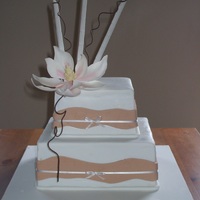 Two Tier Magnolia Cake This is a two tier cake I made. Topped with fondant bamboo and a magnolia flower made from petal paste.