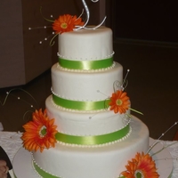 Spring Wedding Cake White round wedding cake with lime green ribbon and orange gerber daisies