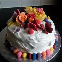 Multi Coloured Cake Chocolate rainbow cake inside - pics to come. Covered in Marshmallow frosting with sugarpaste decorations