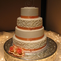 Combed Caked With Scrollwork All buttercream with satin ribbon and pearl pin detail. Brides topper and flowers.