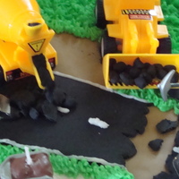 Construction Themed Babyshower Cake! road is made of Black fondant and I rolled individual balls to make it look like asphalt was coming out of the truck and to make it look...