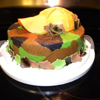 Camo Cake Yellow cake dyed green, black, and tan to look like camo! Frosted with buttercream fosting. The leaves and hat bill are made from a fondant...
