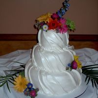 Wildflower Swirl Fondant wedding cake in a swirl design, with fresh flowers.