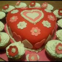 Valentine's Day Cake And Cupcakes heart shaped 2 layer cake frosted with buttercream and covered with fondant. decorations made with fondant and buttercream. a dozen...