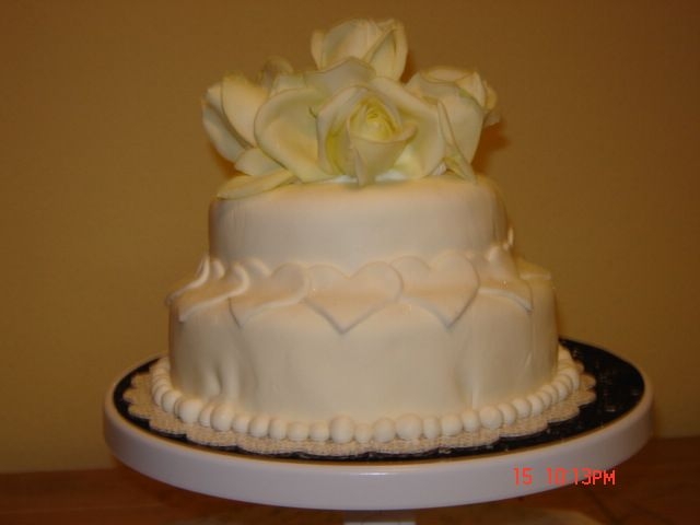 Disk_2_148.jpg Short notice wedding cake. White cake with marshmellow fondant. Its a 6 inch with 8 inch and fresh roses. Not bad for just a hurry hurry...