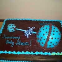 Baby Rattle This is a three layer cake covered in chocolate ganache topped with a baby rattle. Awesome!
