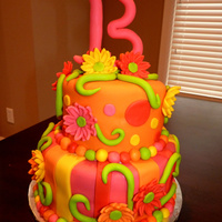 Electric Rainbow Flower Cake All the flowers, the vines and the B are made out of fondant. I used Americolor Electric colors for the entire cake. I made this for a 13...