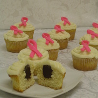 Fundraiser For The Breast Cancer Association Cupcakes with chocolate ganache in the center and decorated with buttercream icing and a fondant rose ribbon.