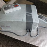 Nintendo Bday Cake Yellow cake with Chocolate Chip cookie dough filling, BC & fondant accents. Controllers are rice Krispy treats. Tried to cover the cake...