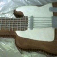 Electric Guitar Choc cake with choc icing. Grey / White marshmallow fondant. Used wilton guitar pan and cut out like telecaster.