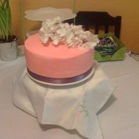 Mom's Birthday Cake Pink Buttercream w/silk flowers and purple ribbon. This is my first all buttercream cake. I need more practice on getting it smooth but all...