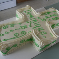 Cross Cake Cross shaped white cake with light green accents..